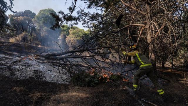 Un bombero trabaja en las tareas de extinción del incendio forestal en la Sierra Oeste de Madrid, en los alrededores del Pantano de San Juan, a 28 de julio de 2026, en Madrid