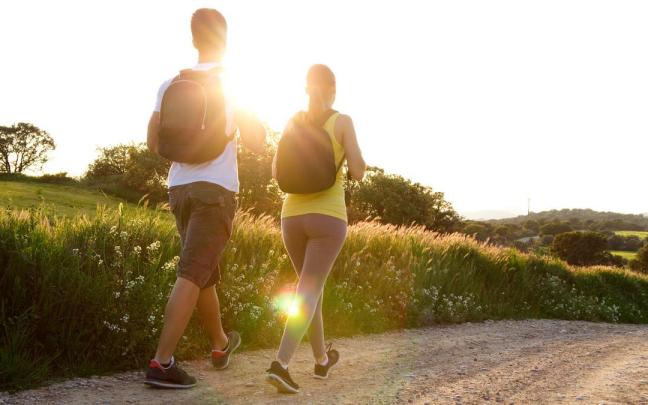 Una pareja camina al atardecer.