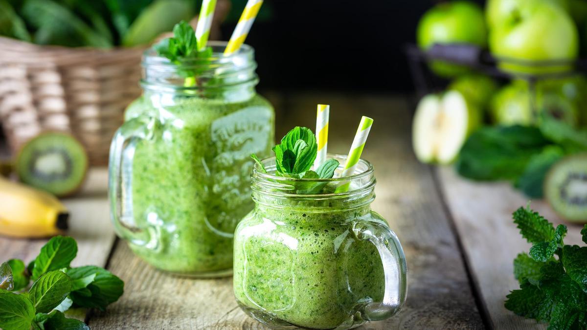 Dos batidos verdes saludables con espinaca, plátano, manzana, kiwi y menta.