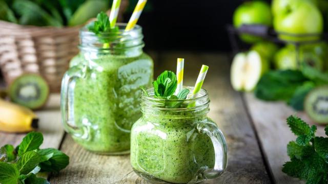 Dos batidos verdes saludables con espinaca, plátano, manzana, kiwi y menta.
