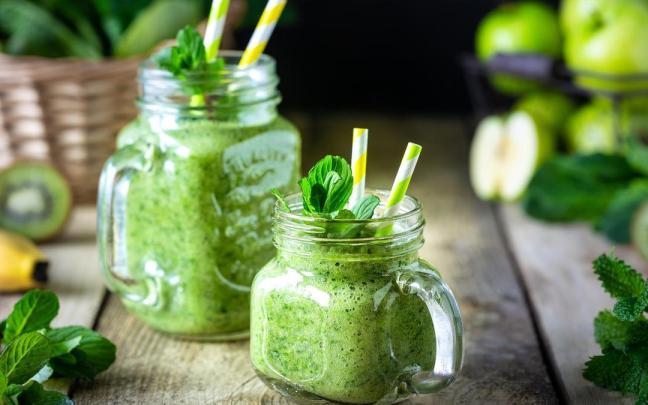 Dos batidos verdes saludables con espinaca, plátano, manzana, kiwi y menta.