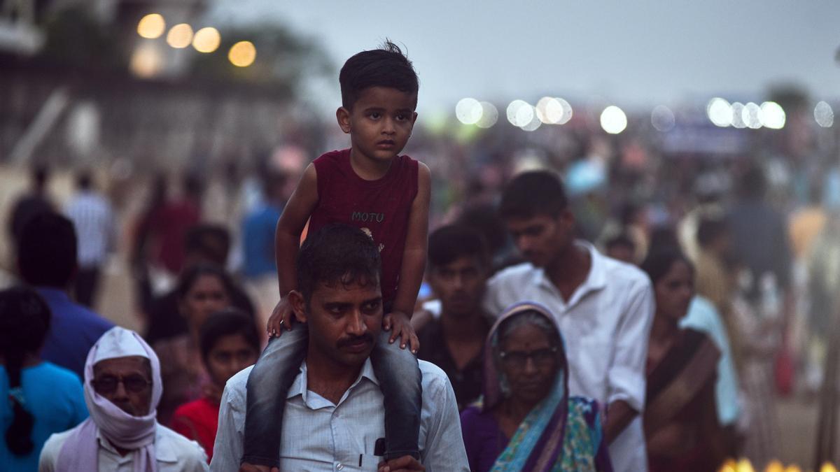 Un hombre carga con su hijo a hombros en Chennai.