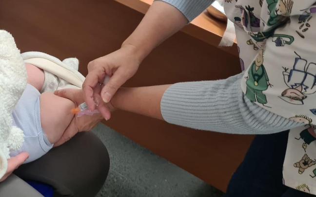 Una enfermera vacuna a un bebé de la tosferina.