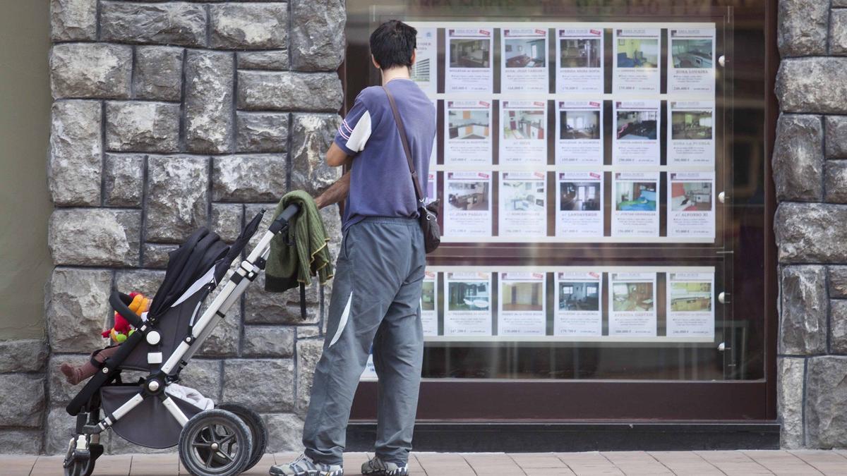 Un hombre mira anuncios de viviendas en una inmobiliaria.