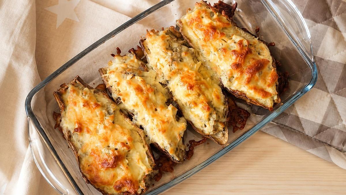 Berenjenas rellenas de pollo y cubiertas con una fina capa de queso gratinado.