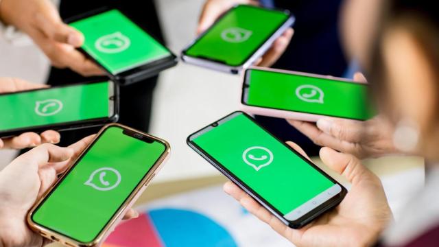 Un grupo de persinas abre la aplicaciónde WhatsApp en sus móviles.