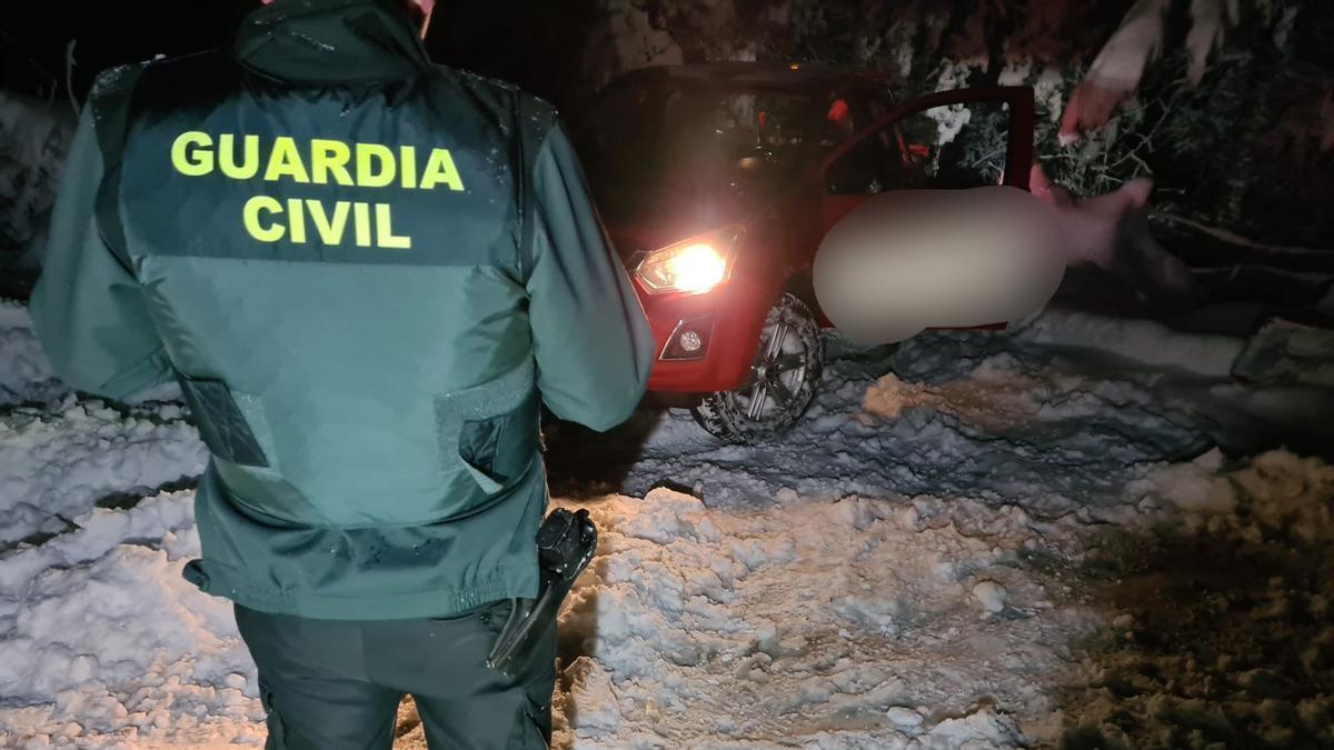 Un agente de Guardia Civil, junto a otro de los vehículos.