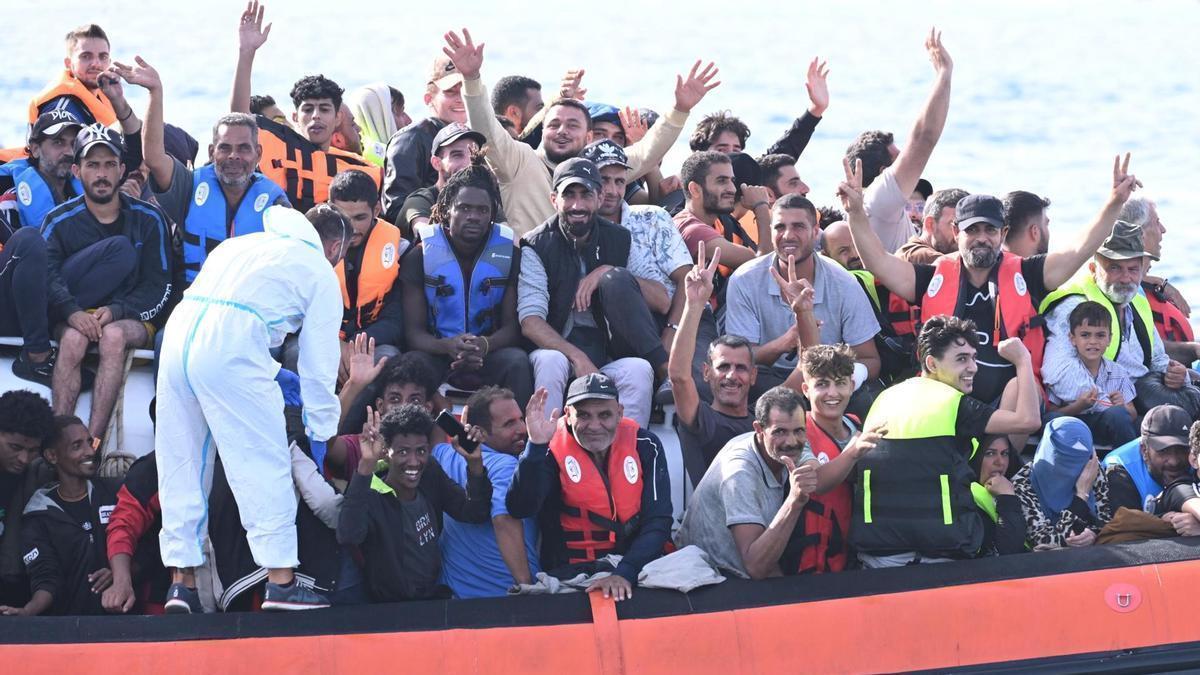 Un grupo de inmigrantes sonríe a su llegada al puerto de Lampedusa.