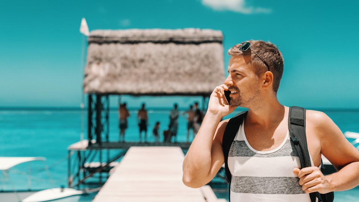 Un hombre habla por el móvil desde su lugar de vacaciones.