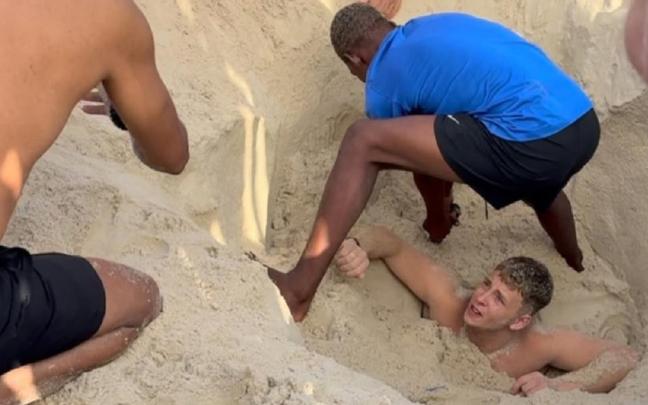 El joven, mientras intentan rescatarlo.