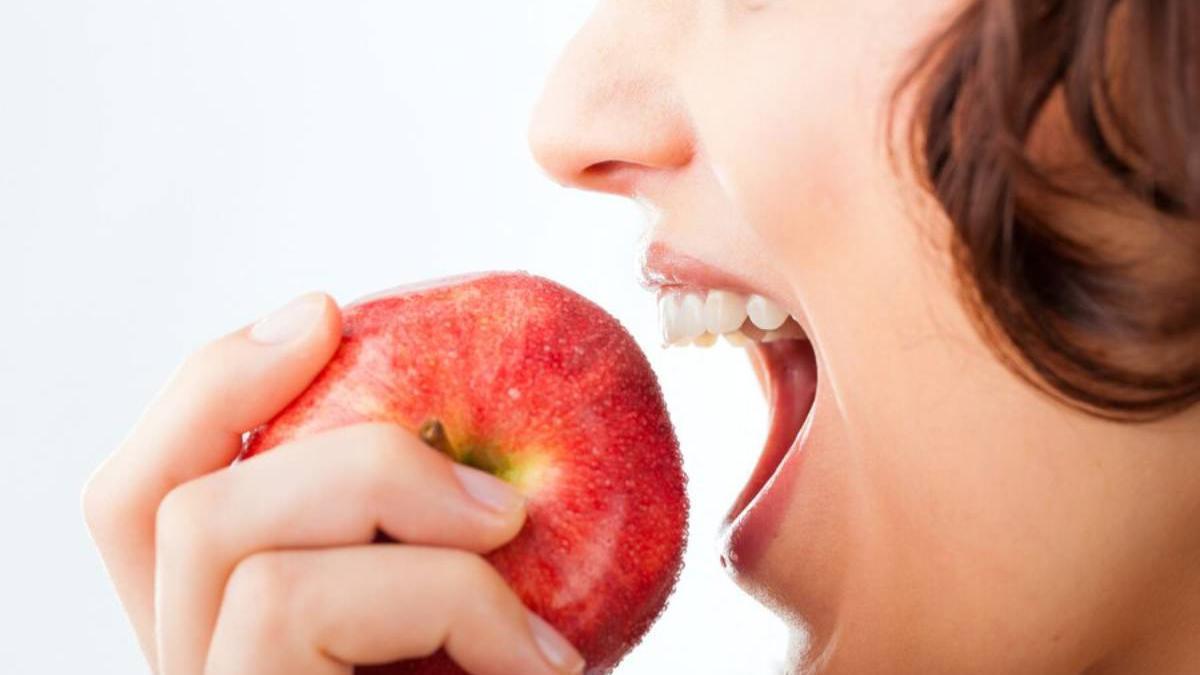 Primer plano de una mujer comiendo una manzana