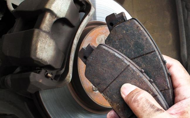 Un mecánico reemplaza unas pastillas de freno desgastadas.
