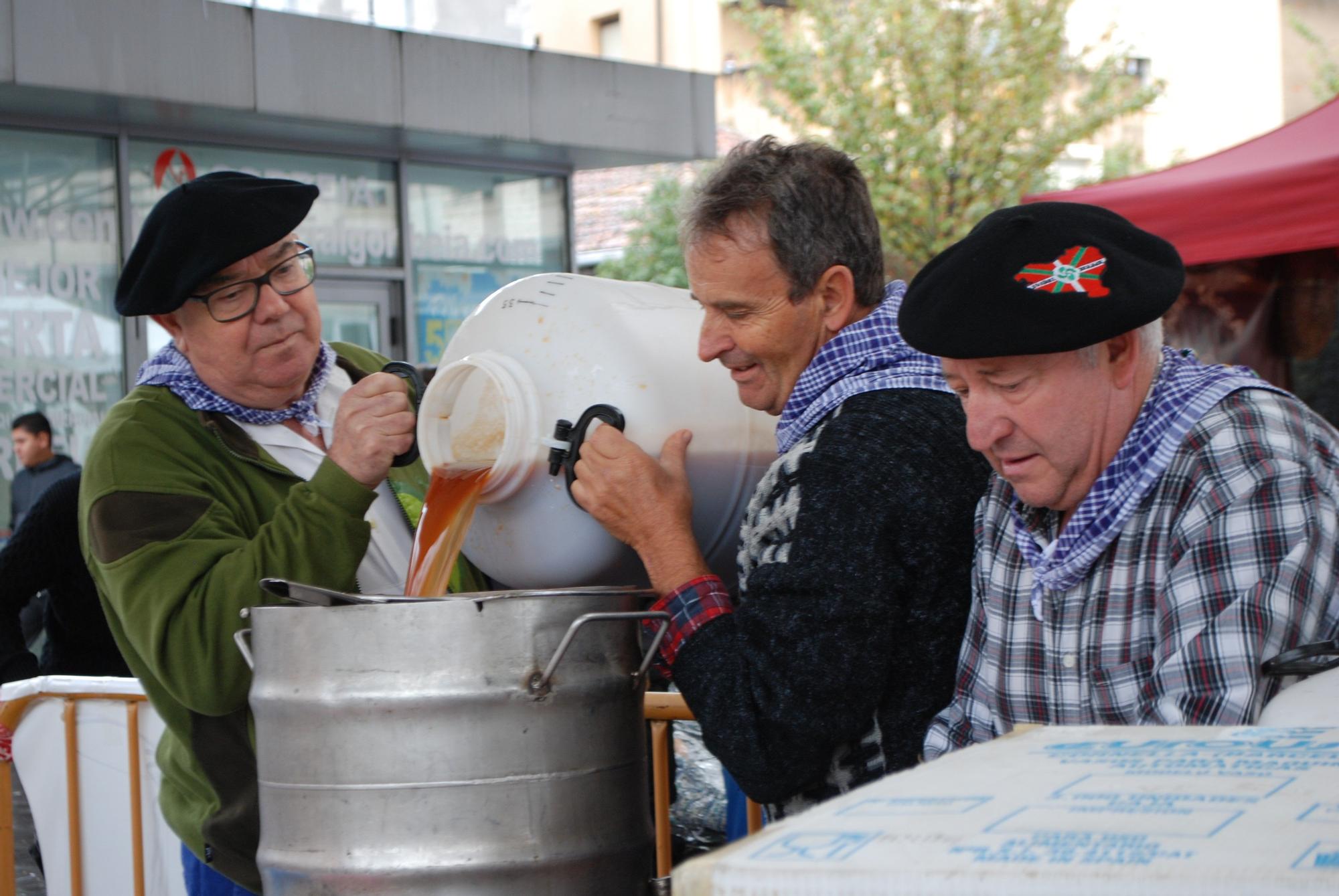 Miembros de Kukutxe San Blas trasegando el zumo de manzana extraído en la prensa para que fermente y se convierta en sidra