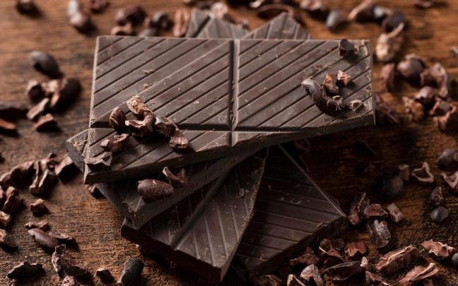 Onzas de chocolate negro apiladas sobre una mesa.