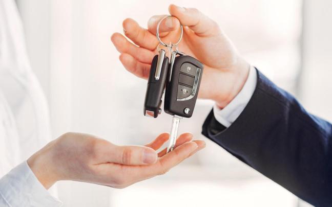 Una persona entrega a otra un juego de llaves de un coche.