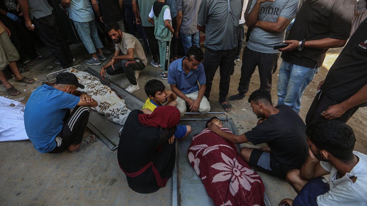 Grupos de palestinos velan los cadáveres de familiares muertos tras un ataque israelí.