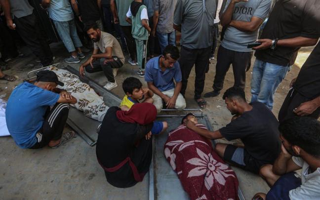Grupos de palestinos velan los cadáveres de familiares muertos tras un ataque israelí.