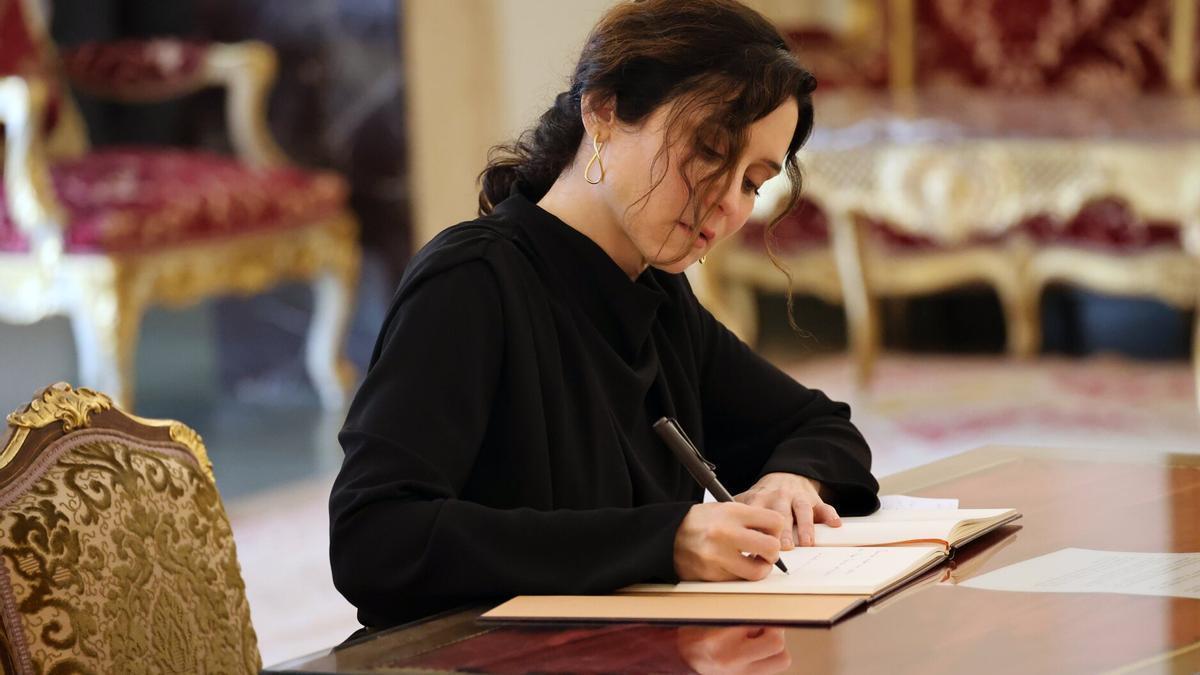 Isabel Díaz Ayuso, firmando en el libro de condolencias.