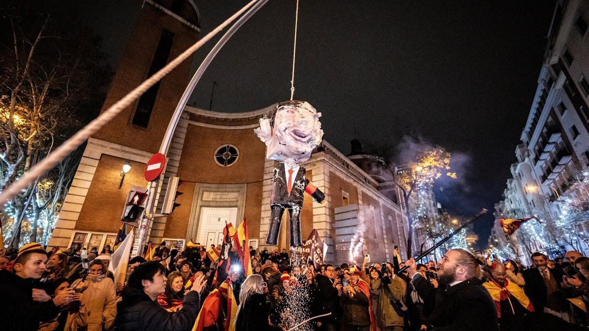 Decenas de personas celebran la entrada del año nuevo en la calle Ferraz, a 1 de enero de 2024. Revuelta, la organización juvenil de la órbita de Vox convocante de las concentraciones en Ferraz, ha llamado a tomar las uvas esta Nochevieja f