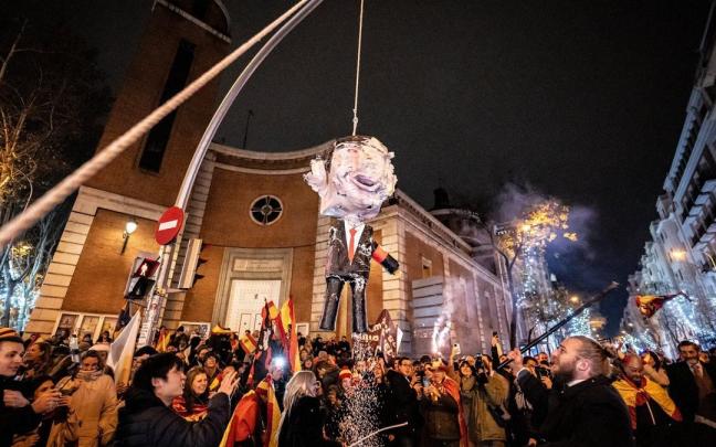 Decenas de personas celebran la entrada del año nuevo en la calle Ferraz, a 1 de enero de 2024. Revuelta, la organización juvenil de la órbita de Vox convocante de las concentraciones en Ferraz, ha llamado a tomar las uvas esta Nochevieja f