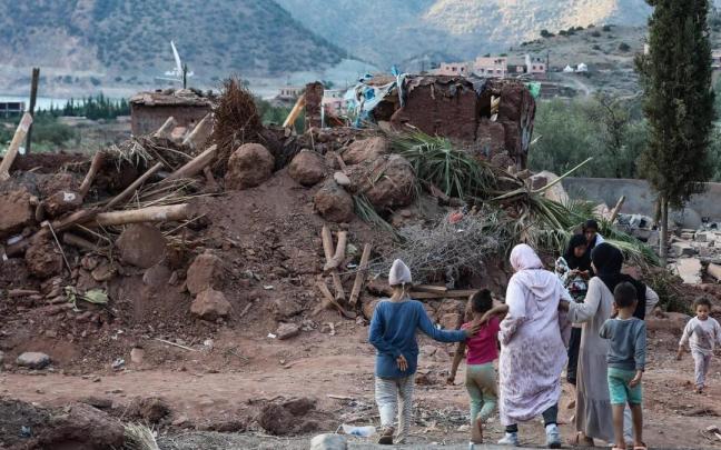 Un grupo de mujeres y niños junto a los escombros de una vivienda en Al Haouz, Marruecos. Un grupo de mujeres y niños junto a los escombros de una vivienda en Al Haouz, Marruecos.