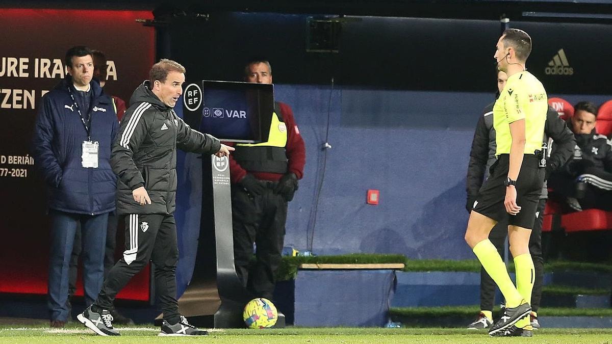 Jagoba Arrasate dialoga con el árbitro Sánchez Martínez, en el partido entre Osasuna y Celta. La pantalla del VAR, al fondo.