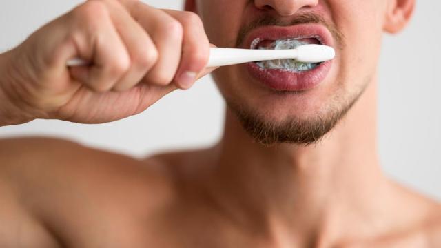 Un joven lavándose los dientes