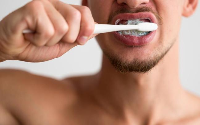 Un joven lavándose los dientes
