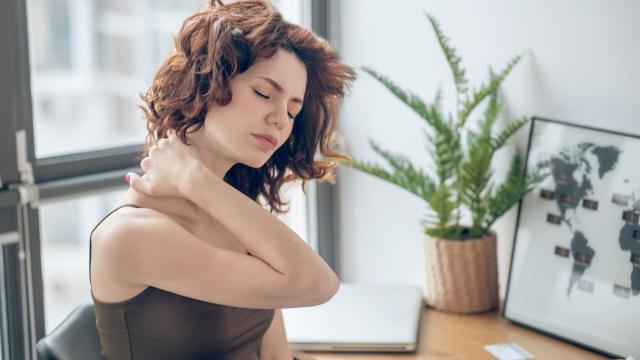 Una mujer con un fuerte dolor en el cuello.