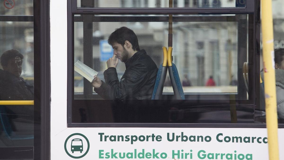 Un joven leyendo en el transporte público.