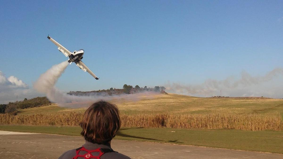 Una persona pilotando un avión de aeromodelismo.