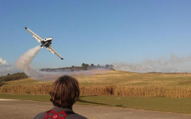 Una persona pilotando un avión de aeromodelismo.
