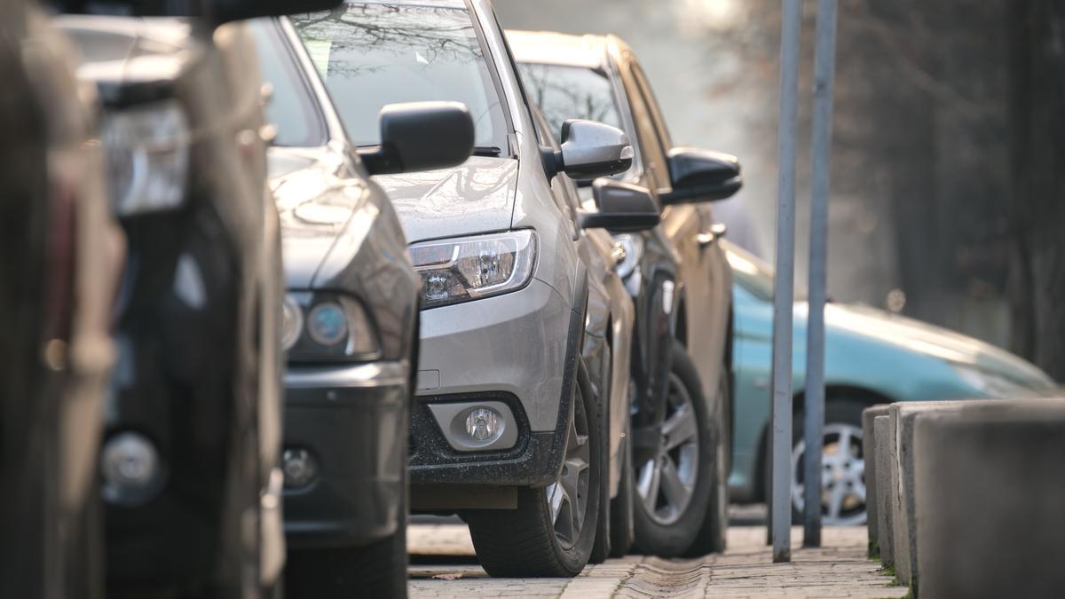Unos coches aparcados en una calle en cuesta.