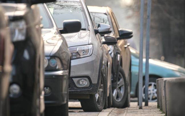 Unos coches aparcados en una calle en cuesta.