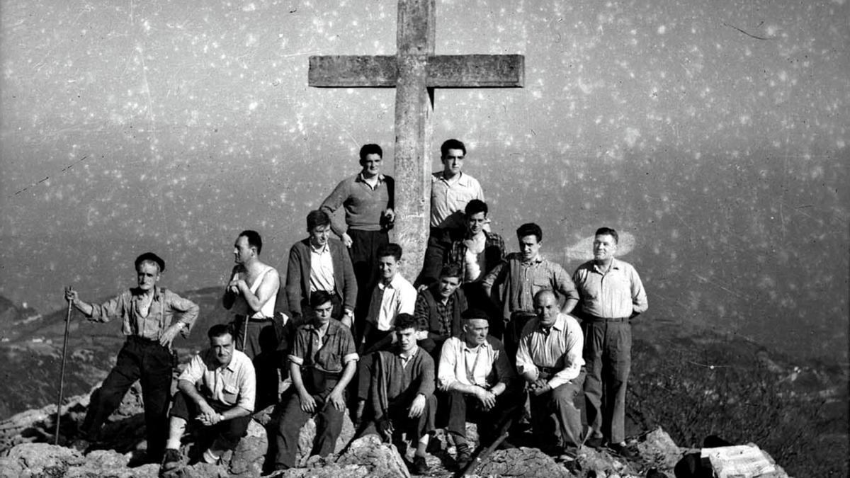 Un grupo de montañeros posa, en 1958, junto a la cruz del monte Arno que sustituyó a la que un rayo destruyó en 1930