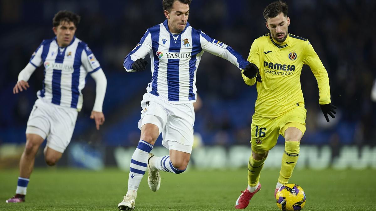 Martin Zubimendi persigue a Álex Baena en presencia de Aramburu, este lunes en Anoeta. / AFP7 VÍA EUROPA PRESS