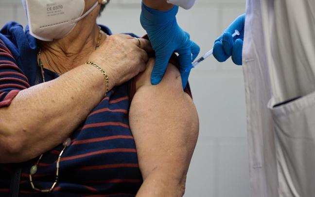 Un enfermero vacuna a una mujer de la gripe. Un enfermero vacuna a una mujer de la gripe.