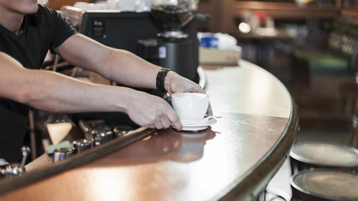 Una camarera sirviendo un café.