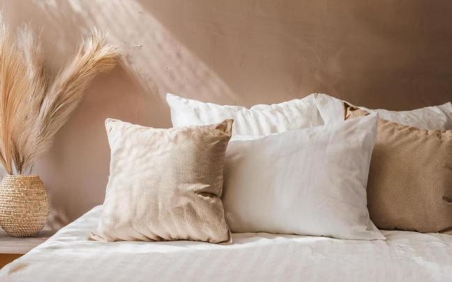 Cojines y textiles naturales para un dormitorio muy acogedor.