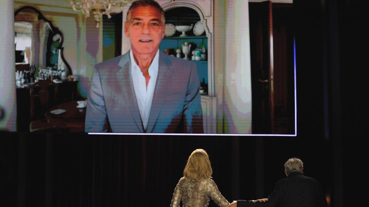 Cate Blanchett escucha el mensaje de George Clooney.