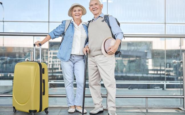 Un matrimonio mayor posa en el aeropuerto antes de tomar el avión. Un matrimonio mayor posa en el aeropuerto antes de tomar el avión.