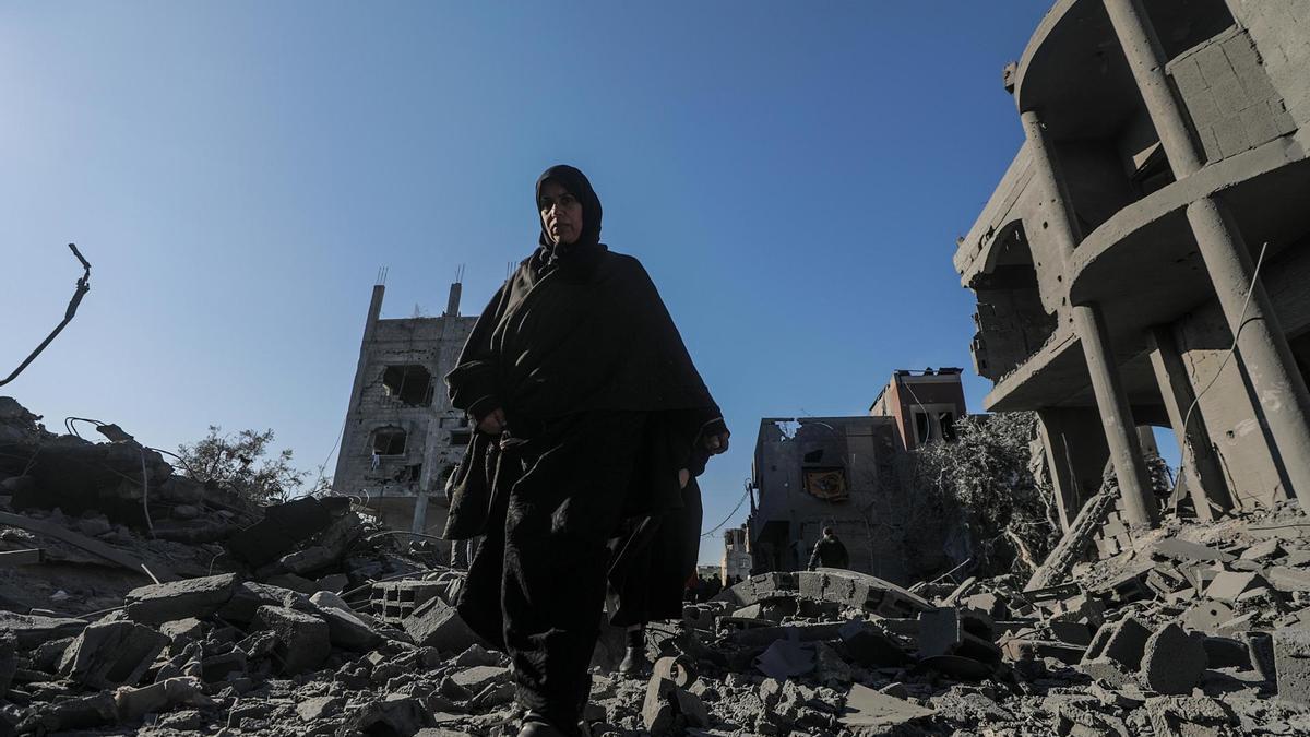 Una mujer camina entre los escombros tras un ataque israelí