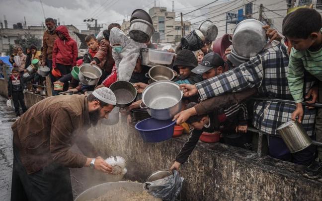 Un hombre reparte comida en un campo de refugiados en Rafah.