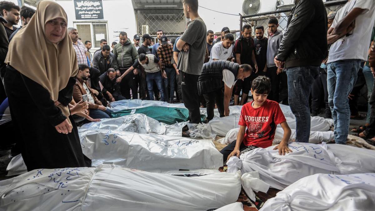 Un grupo de palestinos vela los cadáveres de una familia asesinada en un bombardeo israelí.
