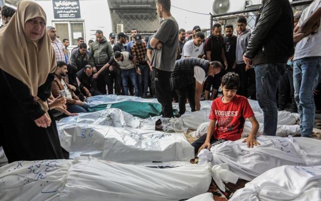 Un grupo de palestinos vela los cadáveres de una familia asesinada en un bombardeo israelí.