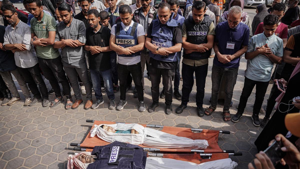 Profesionales de la prensa velan a un compañero muerto en la guerra de Gaza.