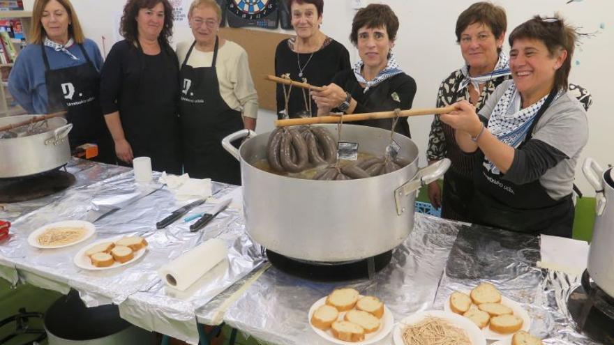 Varias mujeres del grupo organizador, mostrando las morcillas.