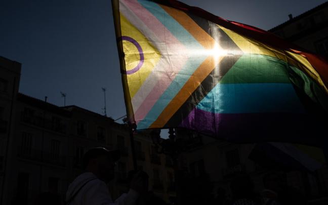 Una bandera a contraluz durante una manifestación por la Ley Trans.