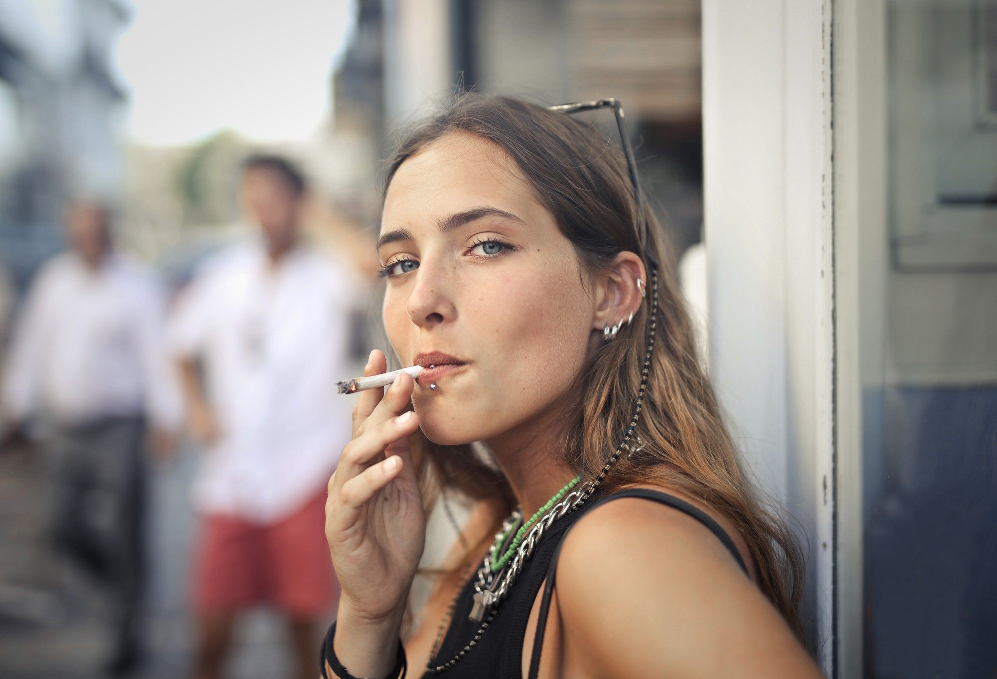 Una mujer joven fuma un cigarrillo.