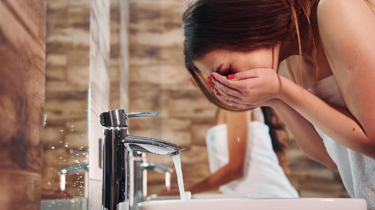 Una mujer se lava la cara.